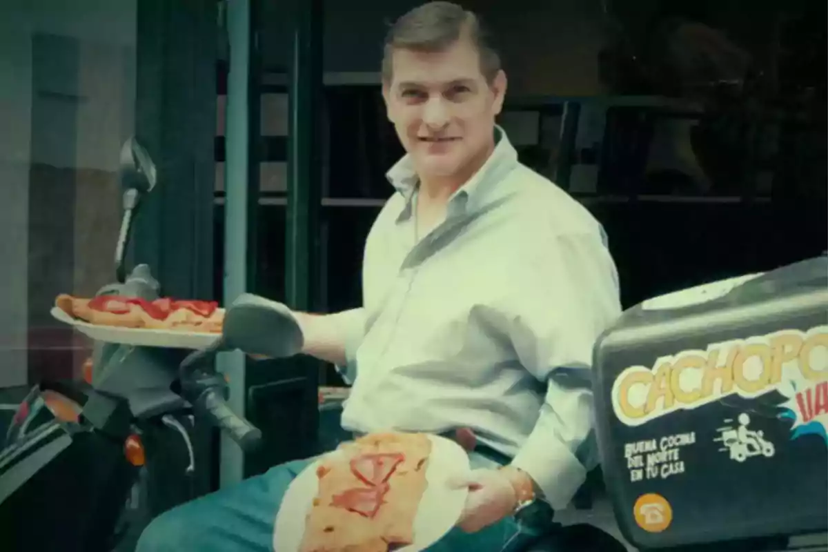 Hombre sonriente sentado en una motocicleta sosteniendo dos platos grandes de comida empanizada con rodajas de jitomate frente a un establecimiento Hombre sonriente sentado en una motocicleta sosteniendo dos platos grandes de comida empanizada con rodajas de jitomate frente a un establecimiento