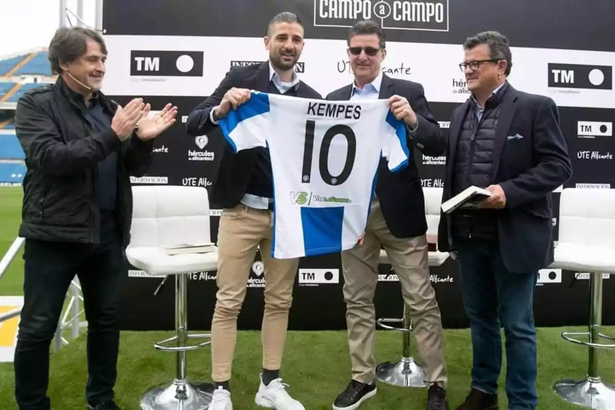 Un grupo de hombres en un evento sostienen una camiseta de fútbol con el número 10 y el nombre 