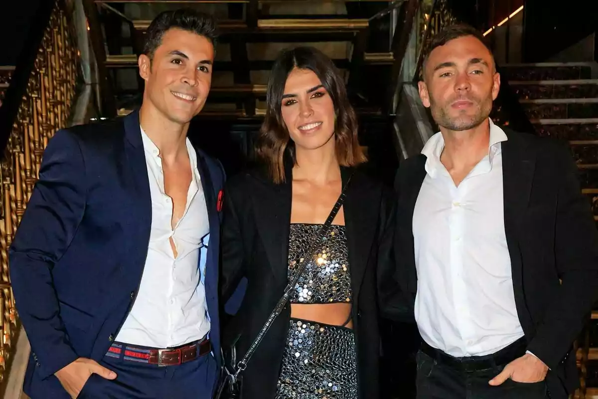 Kiko Jiménez, Sofía Suescun y Cristian Suescun posando juntas en un evento elegante, dos hombres y una mujer, todos vestidos con trajes formales.