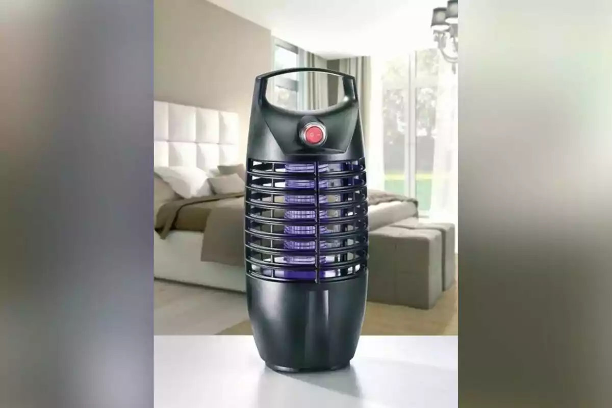 Un dispositivo eléctrico negro con rejillas y un botón rojo en un dormitorio moderno. Un dispositivo eléctrico negro con rejillas y un botón rojo en un dormitorio moderno.