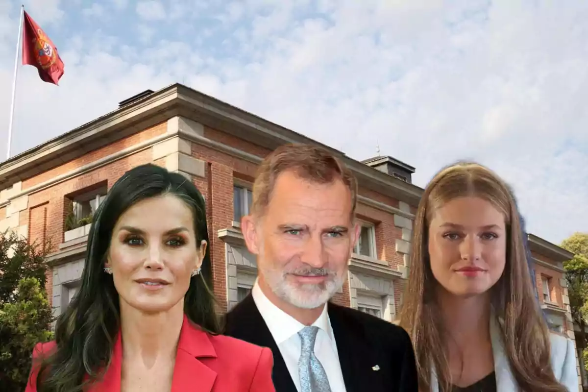 Tres personas posando frente a un edificio de ladrillo con una bandera ondeando en el fondo.