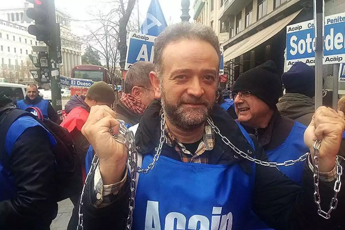 Un grupo de personas participa en una manifestación, llevando chalecos azules con la palabra 