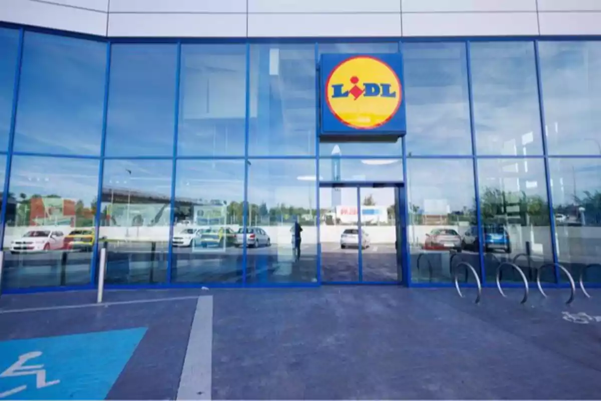 Entrada de una tienda con fachada de vidrio y un logotipo circular en la parte superior. Entrada de una tienda con fachada de vidrio y un logotipo circular en la parte superior.
