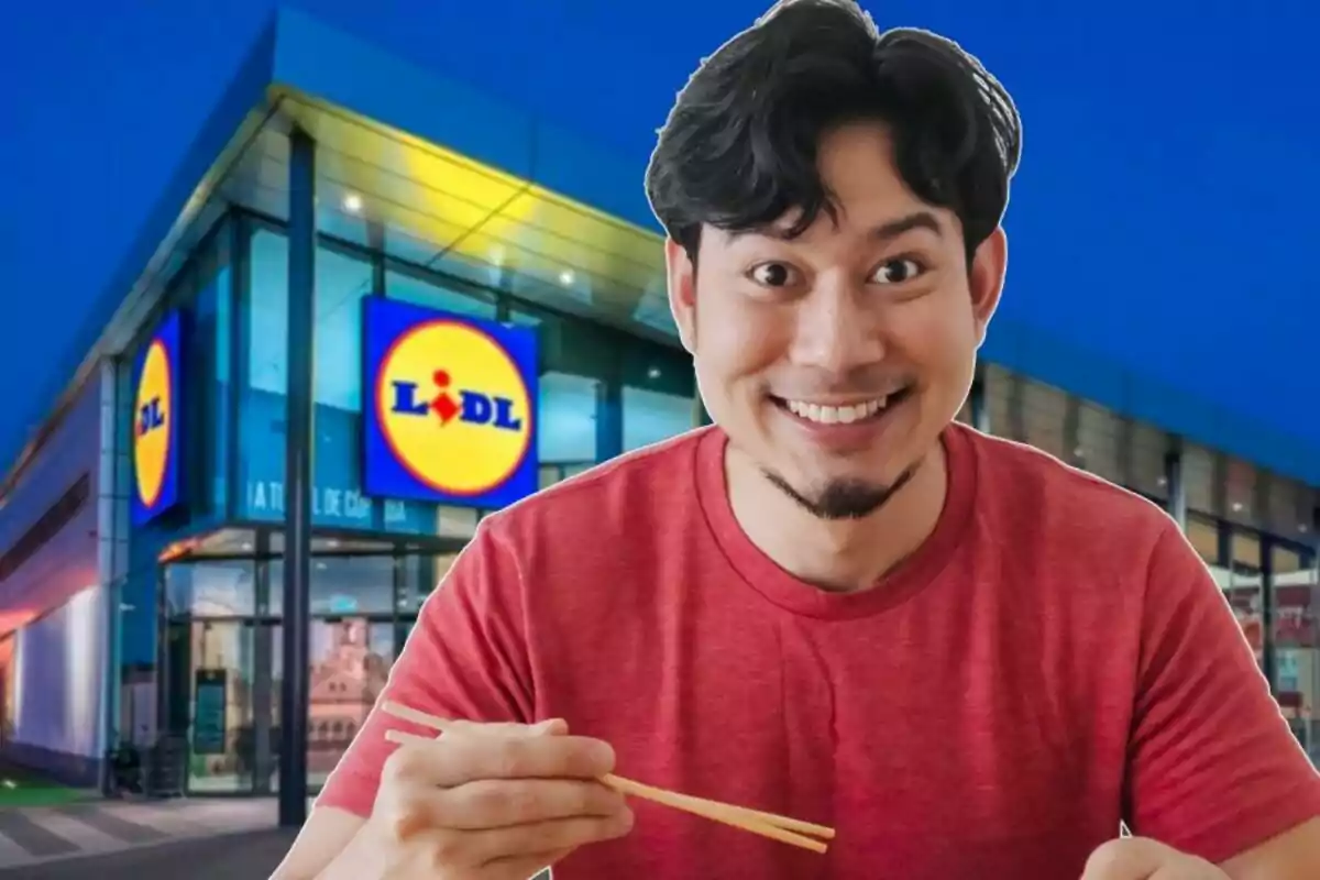 Un hombre sonriente con camiseta roja sostiene palillos frente a una tienda Lidl iluminada por la noche.