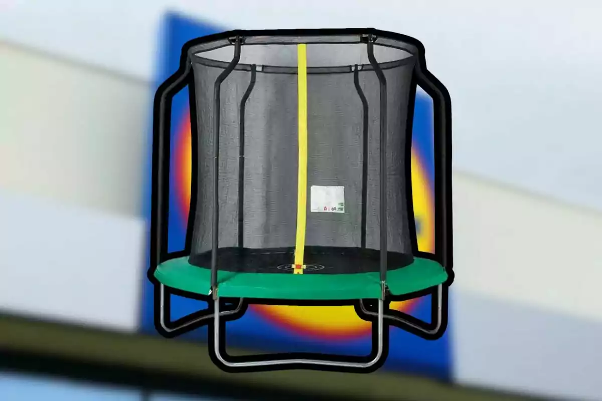 Trampolín infantil con red de seguridad y base verde frente a un fondo desenfocado de una tienda Trampolín infantil con red de seguridad y base verde frente a un fondo desenfocado de una tienda
