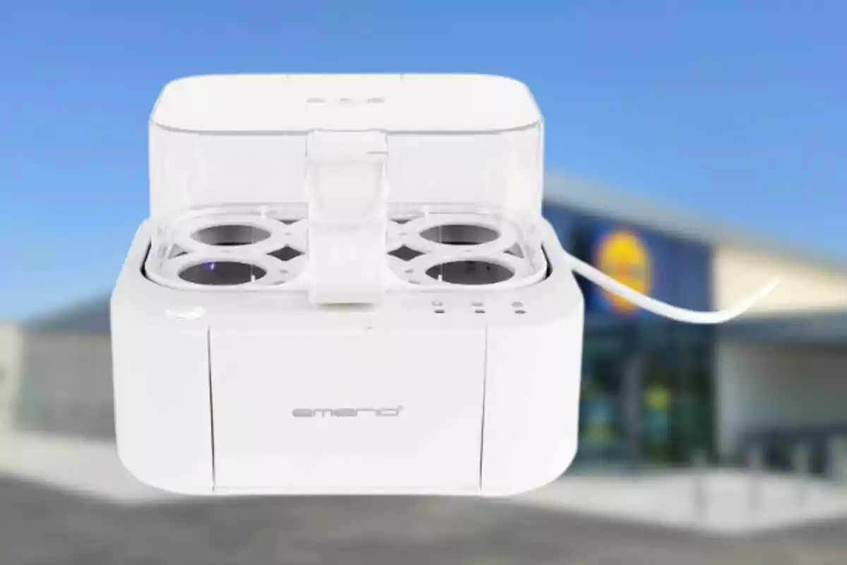 Un dispositivo blanco con compartimentos circulares y una tapa transparente, con un fondo desenfocado de un edificio. Un dispositivo blanco con compartimentos circulares y una tapa transparente, con un fondo desenfocado de un edificio.