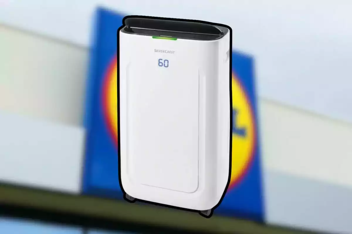 Purificador de aire blanco de la marca SilverCrest con pantalla digital mostrando el número 60 frente a un cartel borroso de la tienda Lidl Purificador de aire blanco de la marca SilverCrest con pantalla digital mostrando el número 60 frente a un cartel borroso de la tienda Lidl
