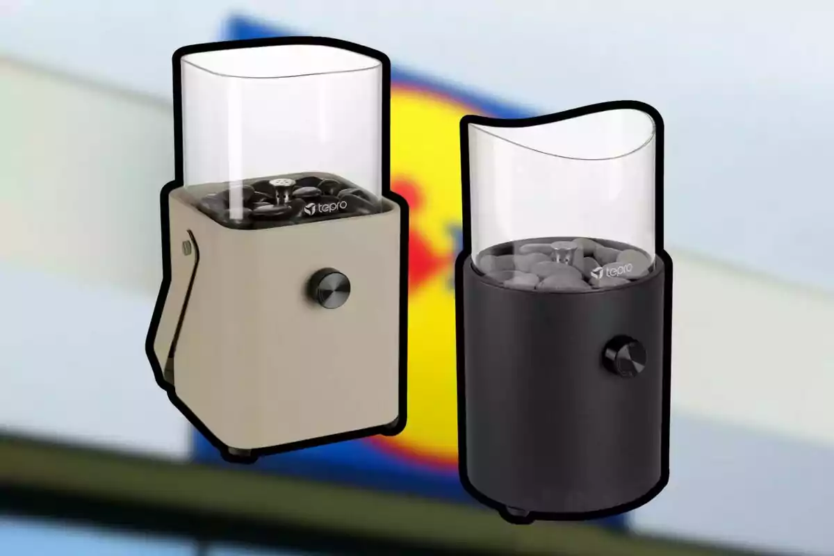 Dos dispositivos cilíndricos con base de color beige y negro, cada uno con un compartimento superior transparente que contiene piedras, sobre un fondo desenfocado. Dos dispositivos cilíndricos con base de color beige y negro, cada uno con un compartimento superior transparente que contiene piedras, sobre un fondo desenfocado.