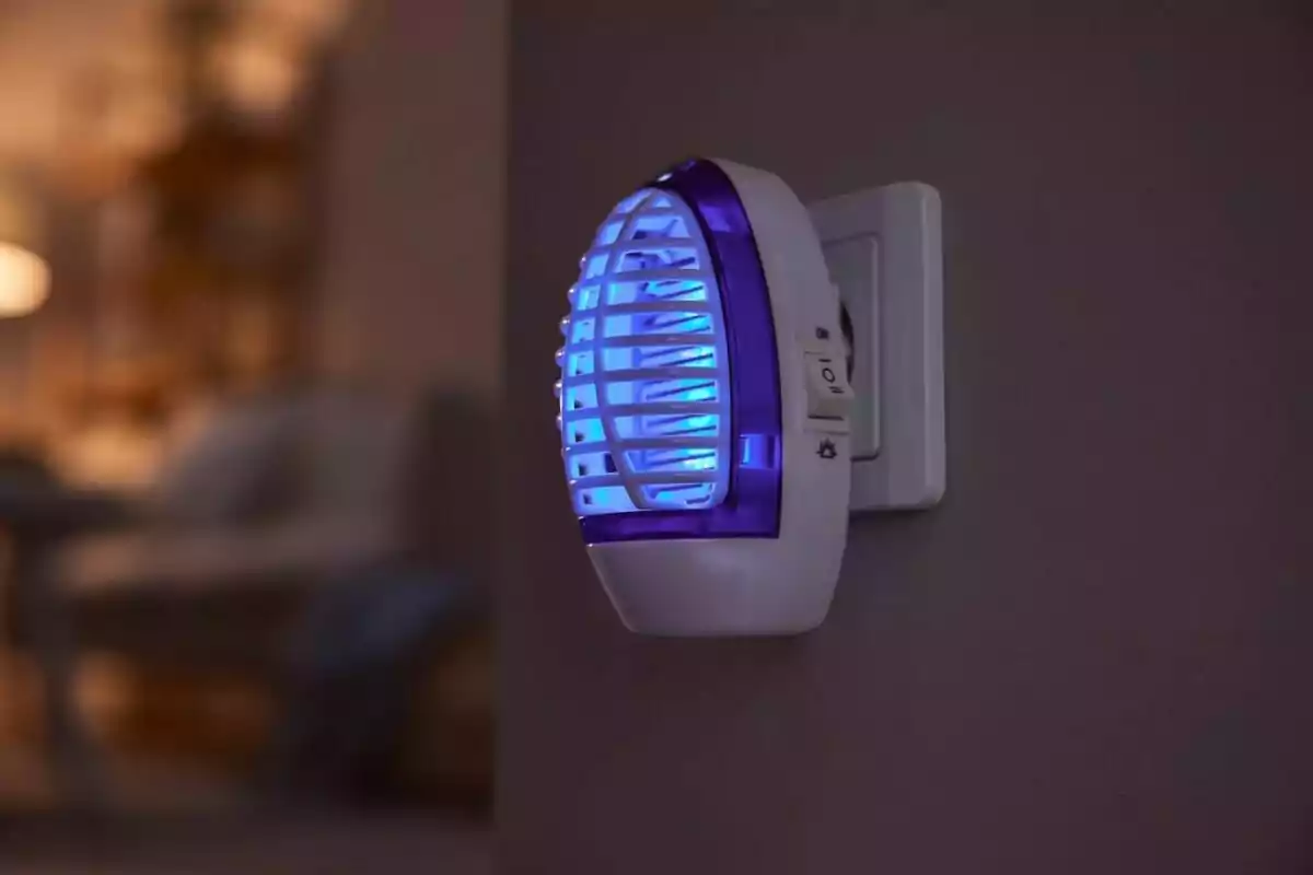 Un dispositivo eléctrico de luz azul enchufado en una pared. Un dispositivo eléctrico de luz azul enchufado en una pared.