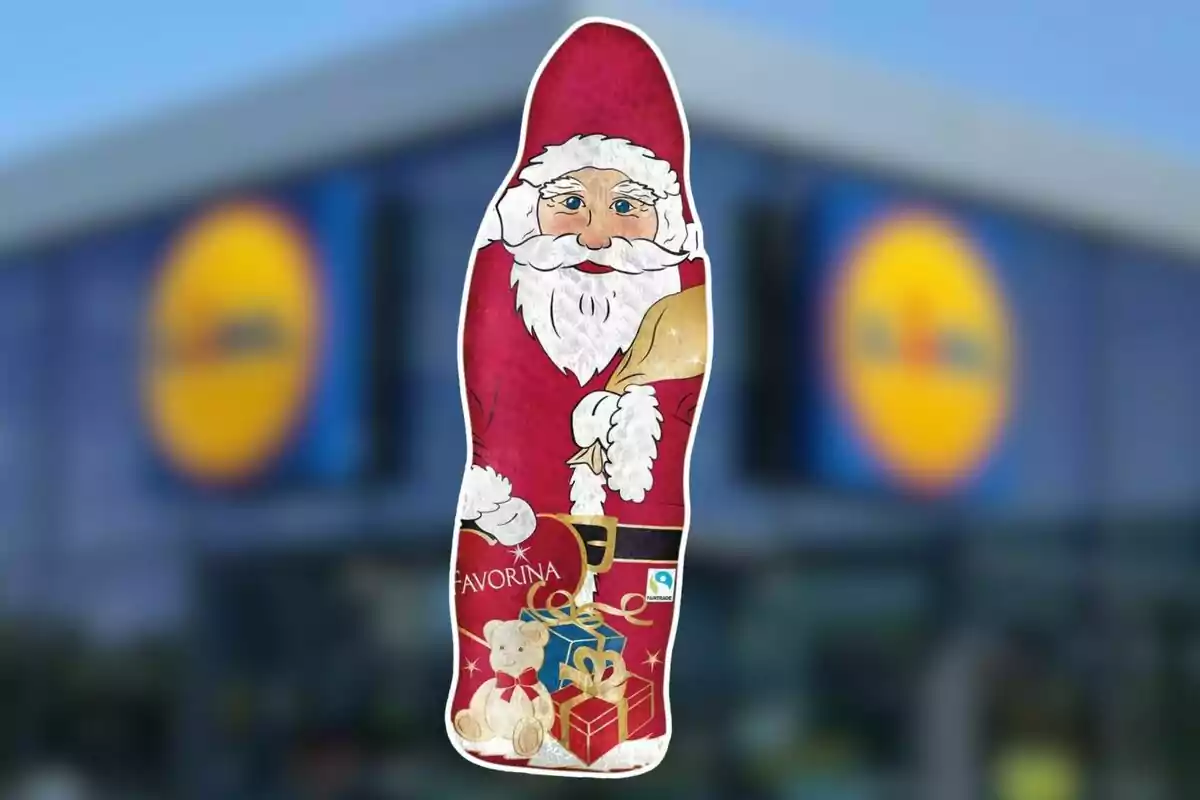 Figura de chocolate con forma de Papá Noel con envoltura roja y detalles navideños, frente a un fondo borroso de una tienda. Figura de chocolate con forma de Papá Noel con envoltura roja y detalles navideños, frente a un fondo borroso de una tienda.
