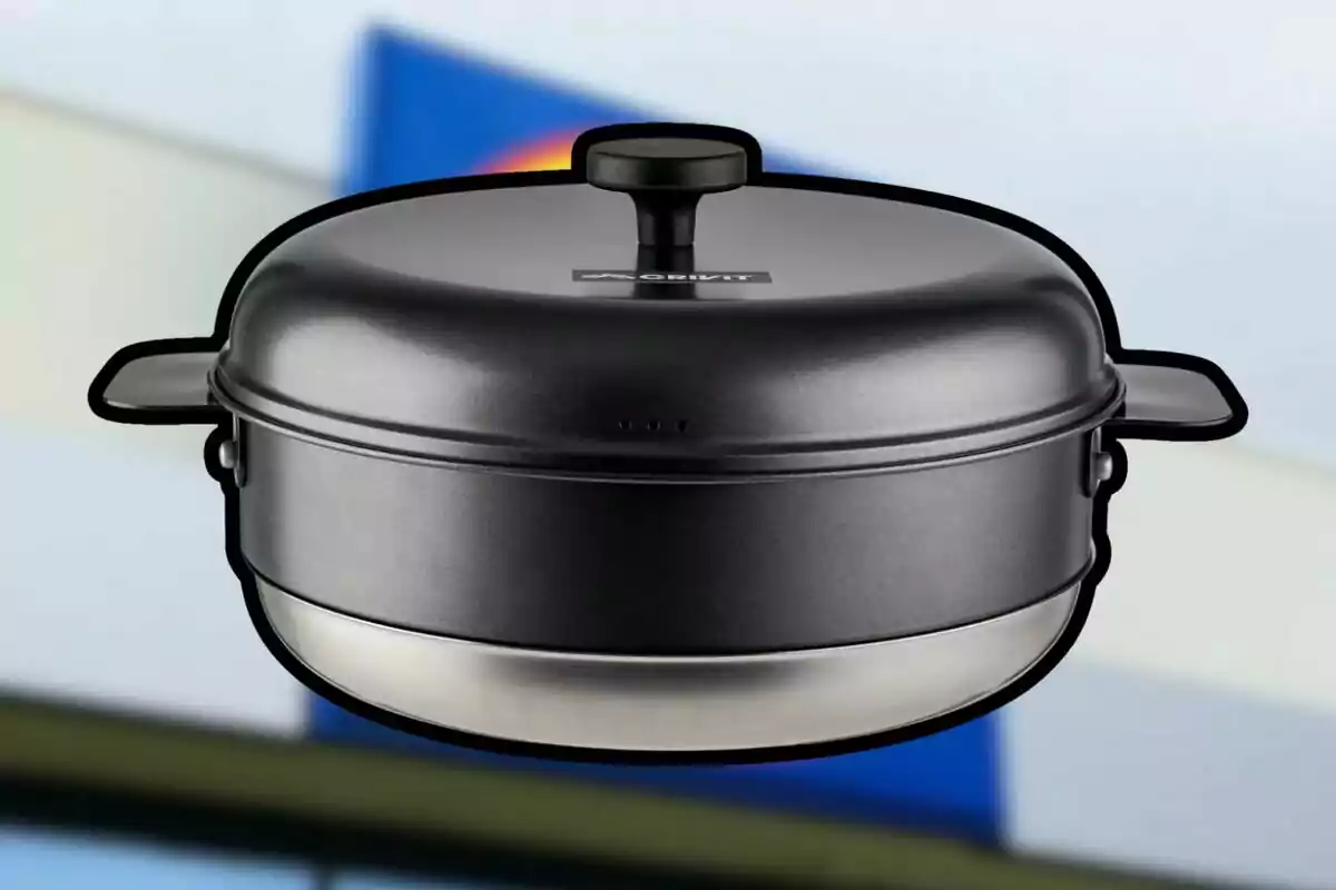 Olla negra con tapa y asas sobre un fondo desenfocado de colores azul, amarillo y blanco Olla negra con tapa y asas sobre un fondo desenfocado de colores azul, amarillo y blanco