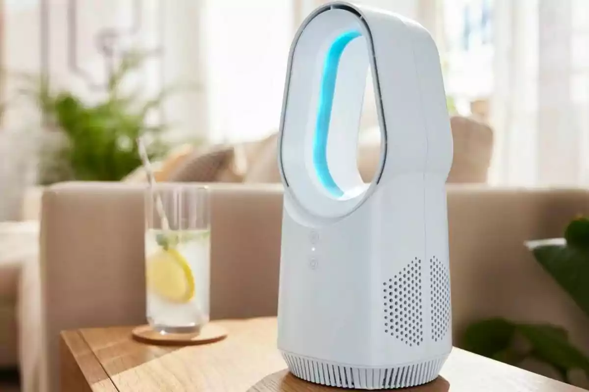 Un ventilador sin aspas de diseño moderno sobre una mesa de madera junto a un vaso de limonada con una rodaja de limón y una pajilla, en un ambiente interior iluminado y acogedor. Un ventilador sin aspas de diseño moderno sobre una mesa de madera junto a un vaso de limonada con una rodaja de limón y una pajilla, en un ambiente interior iluminado y acogedor.
