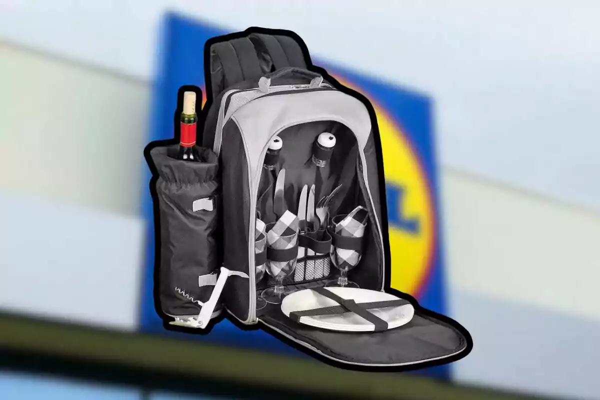 Una mochila de picnic abierta mostrando su contenido, que incluye cubiertos, copas, platos y una botella de vino, con un fondo desenfocado de un logotipo de supermercado. Una mochila de picnic abierta mostrando su contenido, que incluye cubiertos, copas, platos y una botella de vino, con un fondo desenfocado de un logotipo de supermercado.
