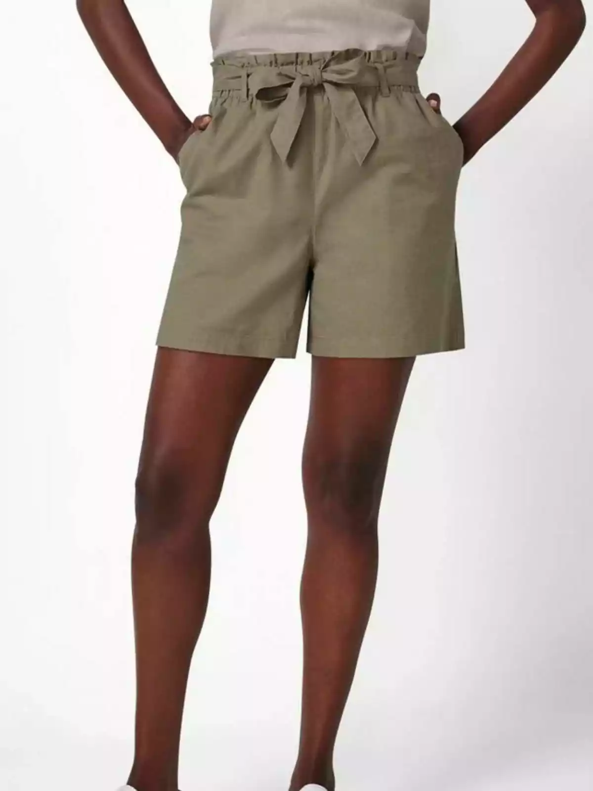 Una persona vistiendo shorts color caqui con un lazo en la cintura. Una persona vistiendo shorts color caqui con un lazo en la cintura.