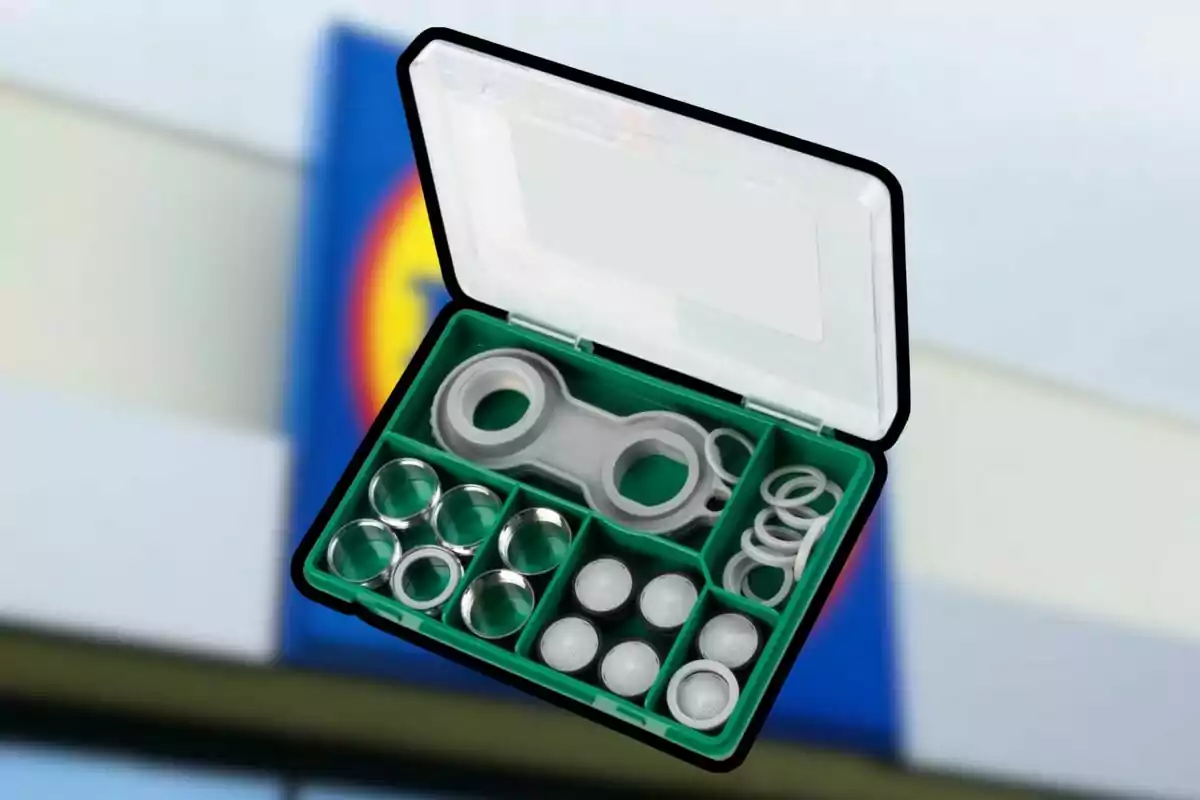 Estuche verde con compartimentos que contiene varias piezas y anillos de metal y plástico sobre un fondo desenfocado Estuche verde con compartimentos que contiene varias piezas y anillos de metal y plástico sobre un fondo desenfocado