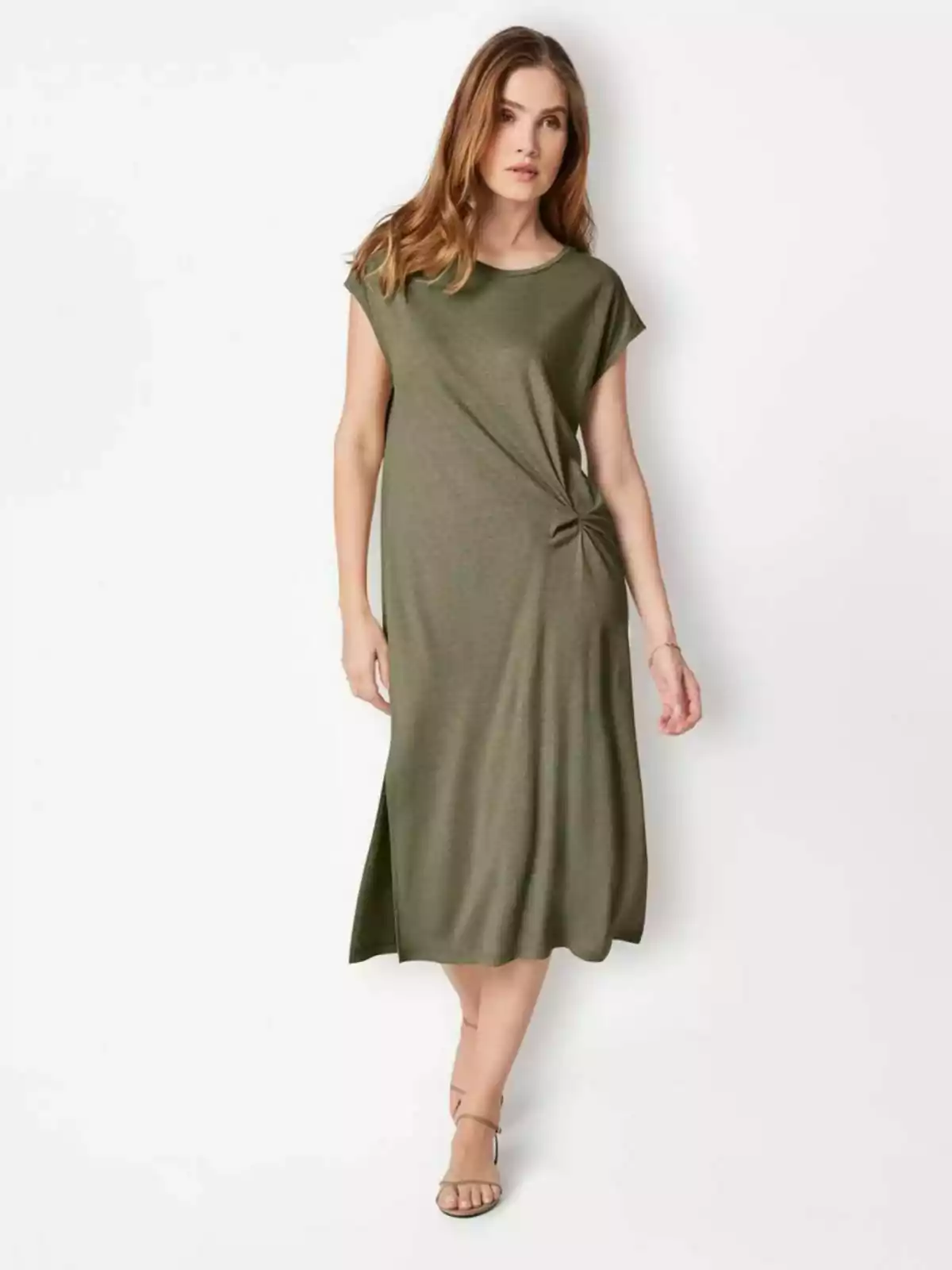 Una mujer con un vestido verde oliva de manga corta y sandalias beige. Una mujer con un vestido verde oliva de manga corta y sandalias beige.