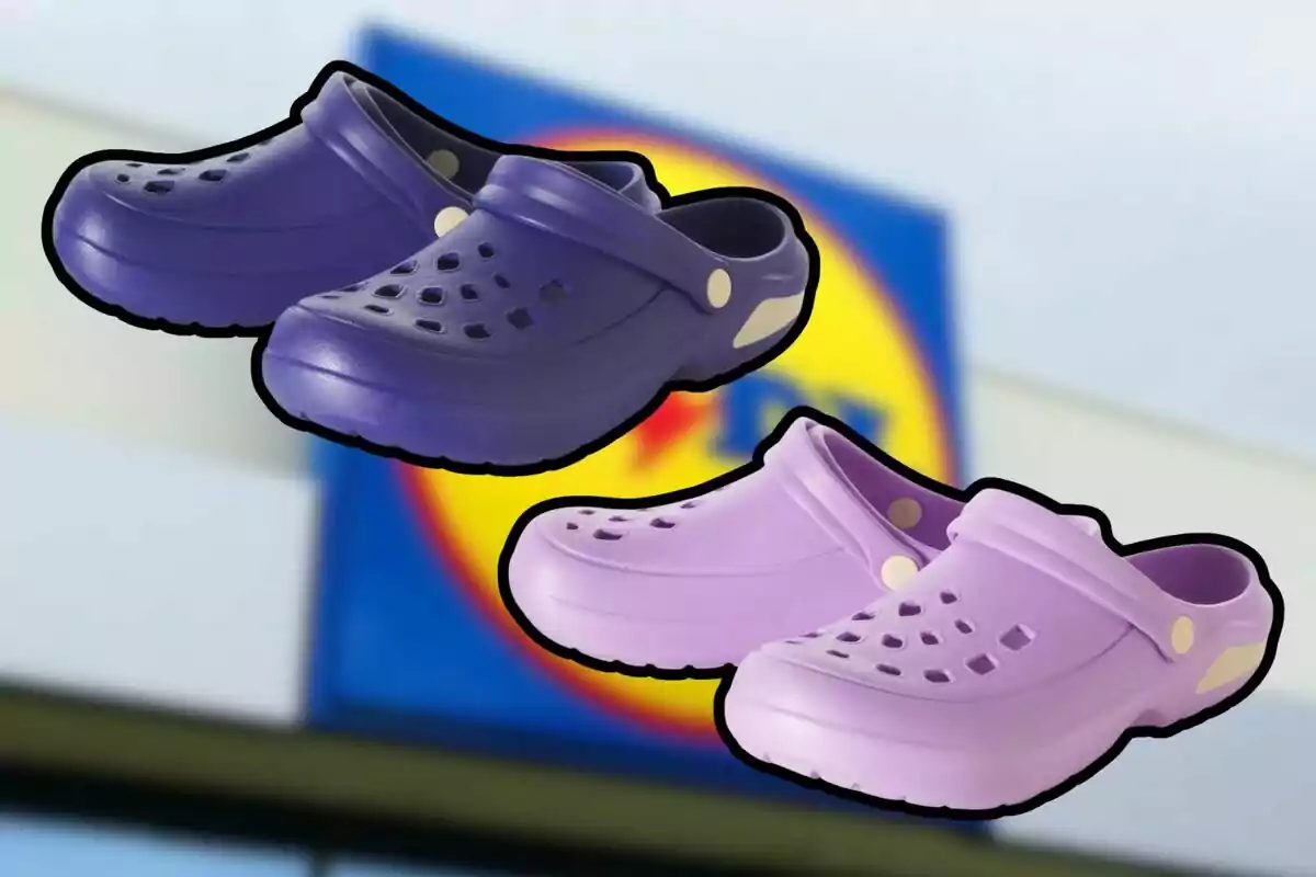 Dos pares de sandalias tipo Crocs en color morado y lila con fondo desenfocado de un letrero de supermercado. Dos pares de sandalias tipo Crocs en color morado y lila con fondo desenfocado de un letrero de supermercado.