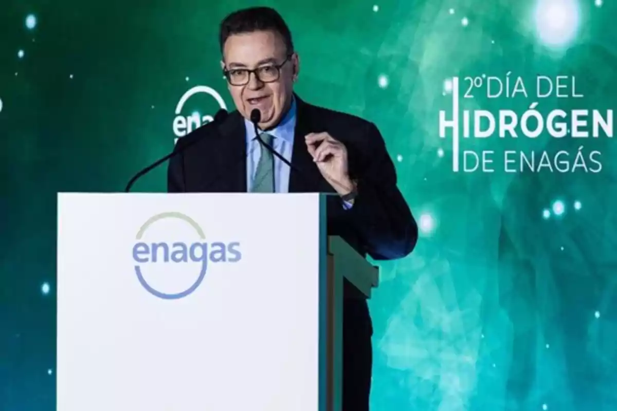 Hombre hablando en un podio con el logo de Enagás y un fondo verde que dice "2º Día del Hidrógeno de Enagás".