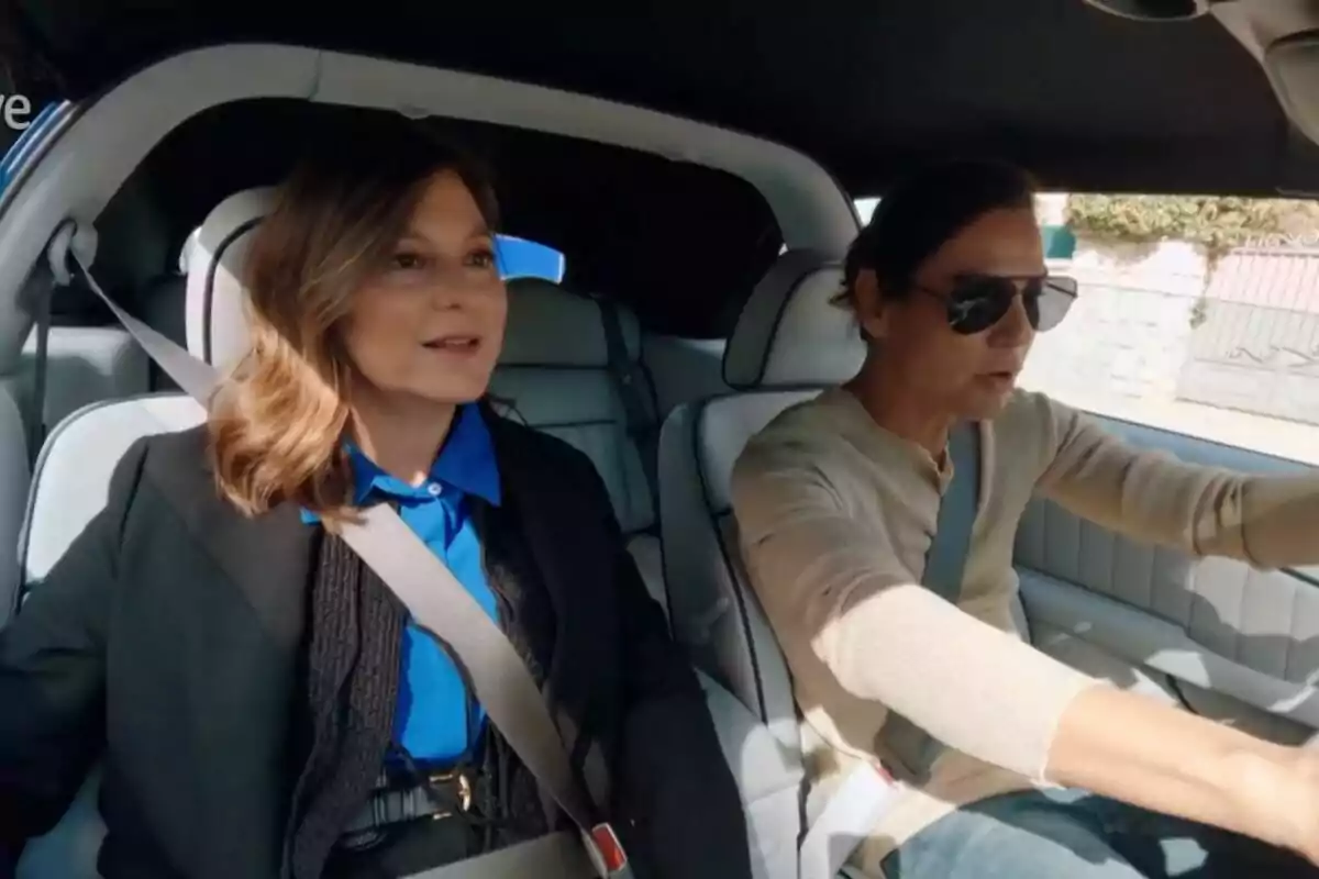 Chabeli Iglesias y Julio Iglesias sentados en un automóvil, ambas con cinturones de seguridad puestos, Chabeli con una camisa azul y Julio con gafas de sol y un suéter beige. Captura de 'Los Iglesias' el 23 de julio de 2024
