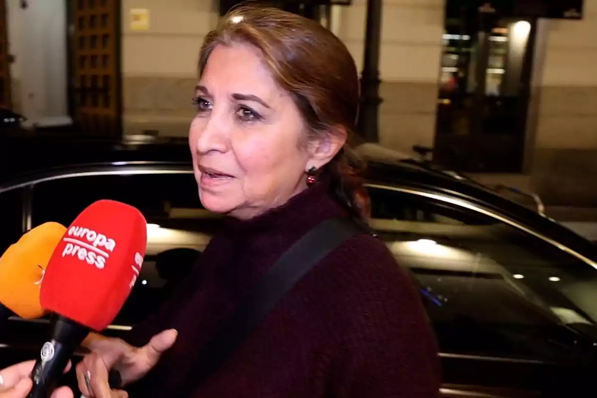 Una mujer siendo entrevistada por reporteros en la calle.