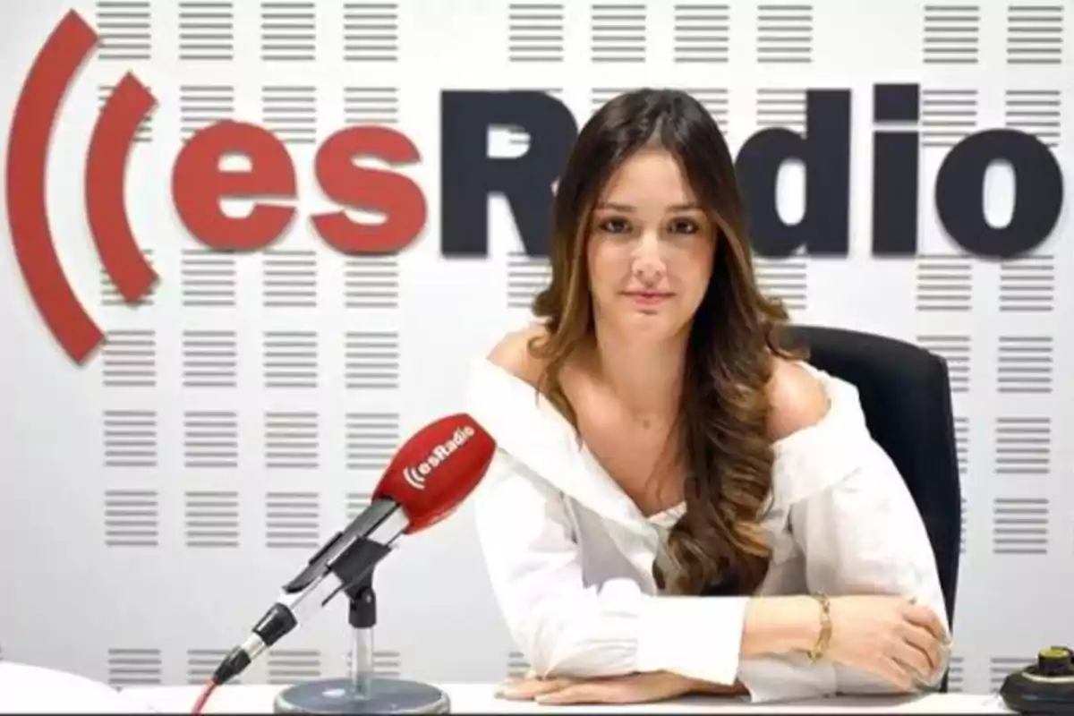Mujer sentada en un estudio de radio con un micrófono rojo frente a ella y el logo de esRadio en el fondo.