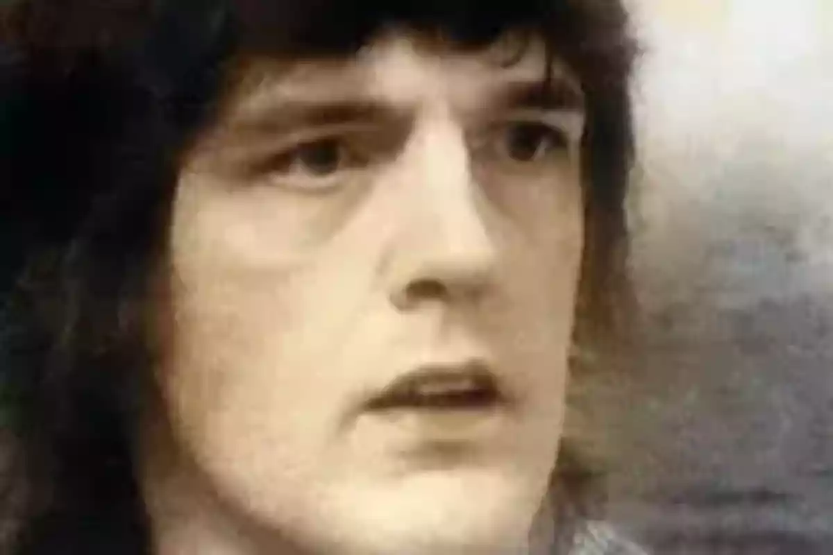 Primer plano de una persona joven con cabello oscuro y expresión seria Primer plano de una persona joven con cabello oscuro y expresión seria