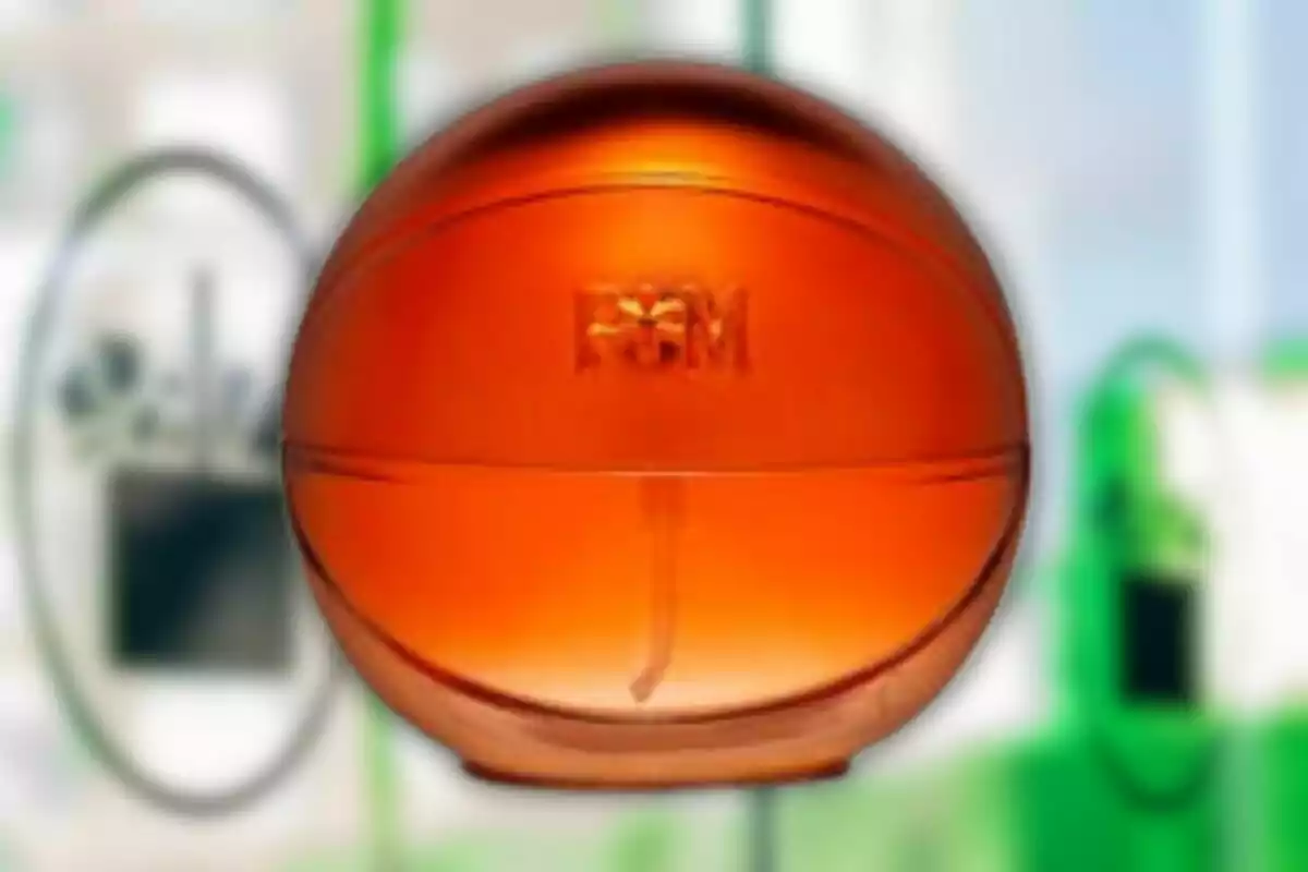 Envase redondo de color naranja translúcido con las letras PGM al frente y fondo desenfocado Envase redondo de color naranja translúcido con las letras PGM al frente y fondo desenfocado