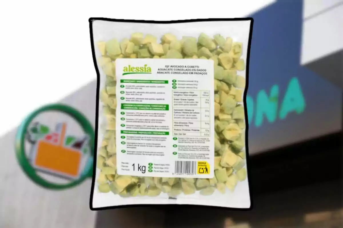 Bolsa de un kilogramo de aguacate congelado en dados de la marca Alessia frente a una tienda Mercadona desenfocada. Bolsa de un kilogramo de aguacate congelado en dados de la marca Alessia frente a una tienda Mercadona desenfocada.