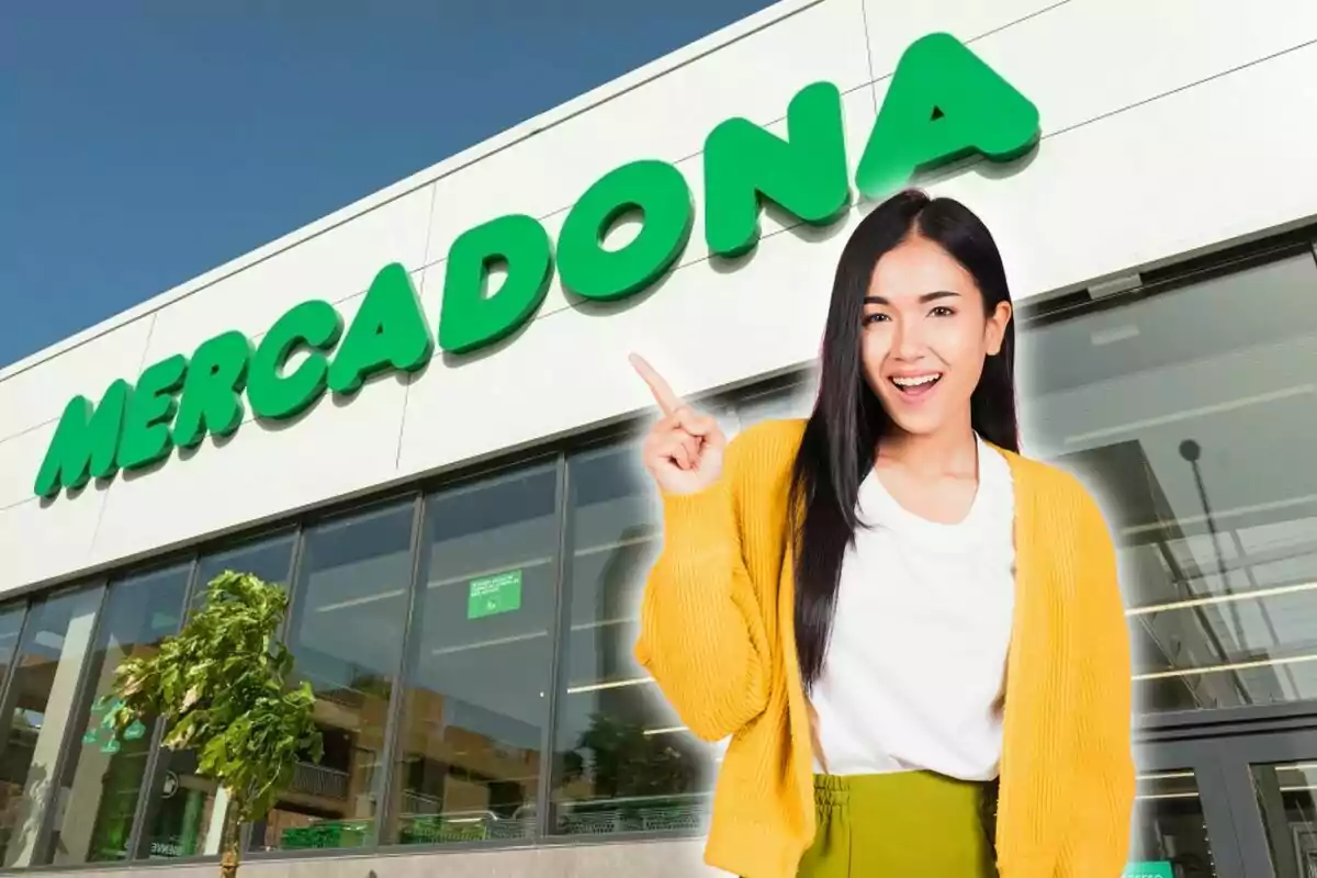 Una mujer sonriente con un suéter amarillo señala hacia el letrero de una tienda Mercadona.