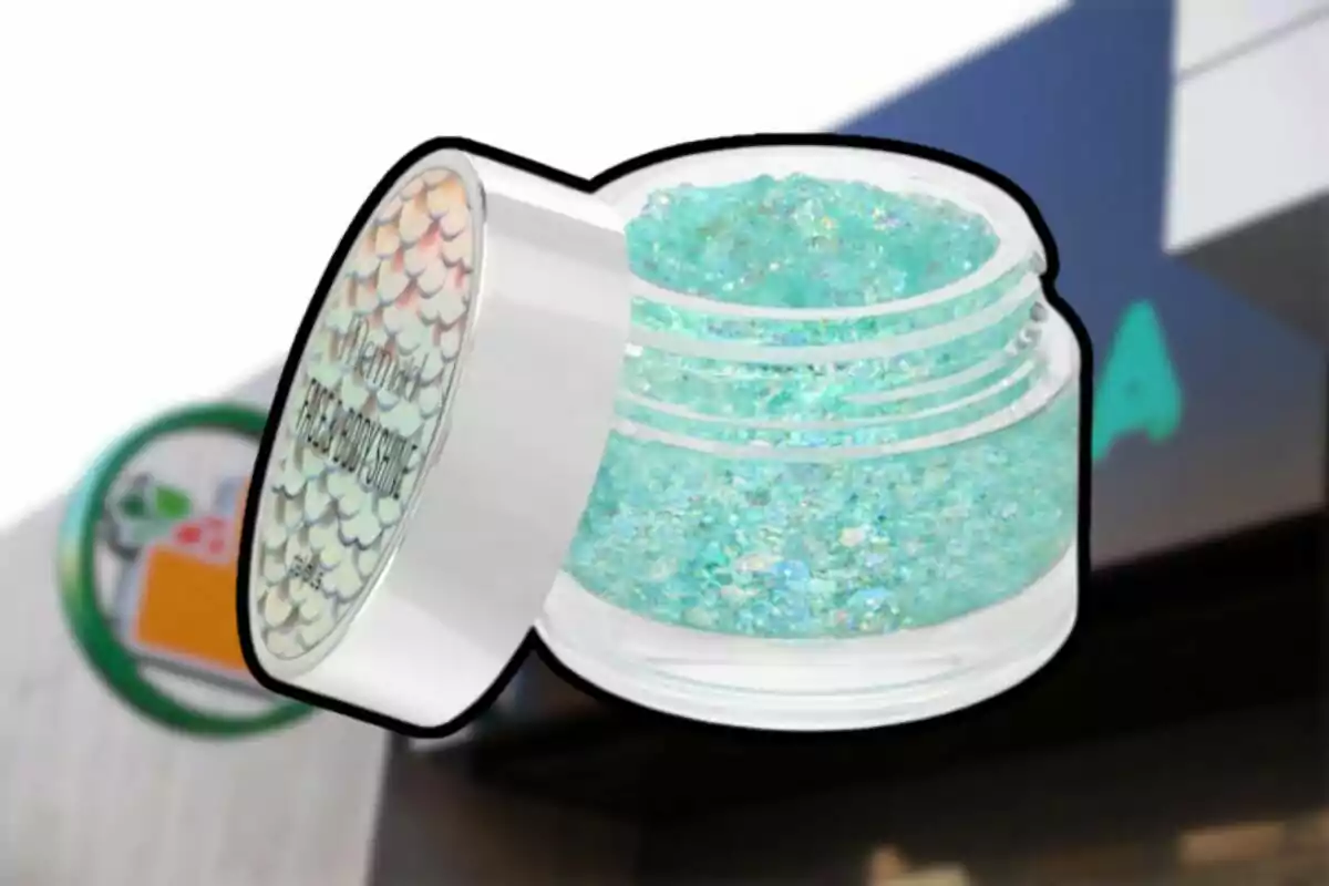 Un frasco de plástico transparente con tapa blanca contiene un producto brillante de color azul verdoso, con un fondo desenfocado que muestra un letrero. Un frasco de plástico transparente con tapa blanca contiene un producto brillante de color azul verdoso, con un fondo desenfocado que muestra un letrero.