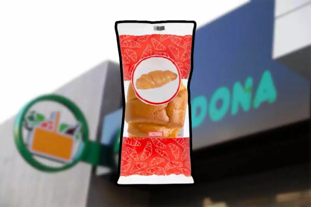 Paquete de pan dulce con diseño de croissants en un fondo que muestra parte de un letrero de supermercado.
