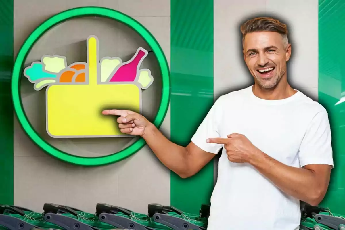 Hombre sonriente con camiseta blanca señalando un letrero de supermercado con un carrito de compras y productos dibujados
