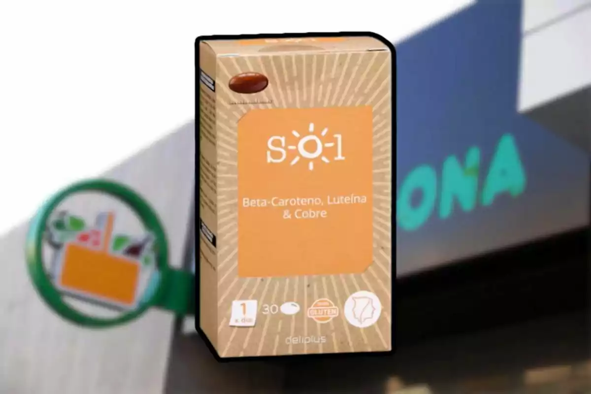 Caja de suplemento alimenticio con beta-caroteno, luteína y cobre de la marca Deliplus frente a un cartel de supermercado. Caja de suplemento alimenticio con beta-caroteno, luteína y cobre de la marca Deliplus frente a un cartel de supermercado.