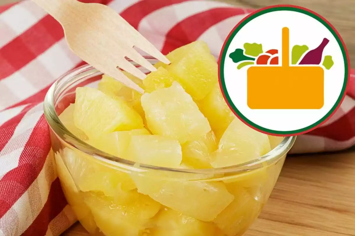 Trozos de piña en un tazón de vidrio con un tenedor de madera y un mantel a cuadros rojos, junto a un icono de canasta de supermercado Trozos de piña en un tazón de vidrio con un tenedor de madera y un mantel a cuadros rojos, junto a un icono de canasta de supermercado