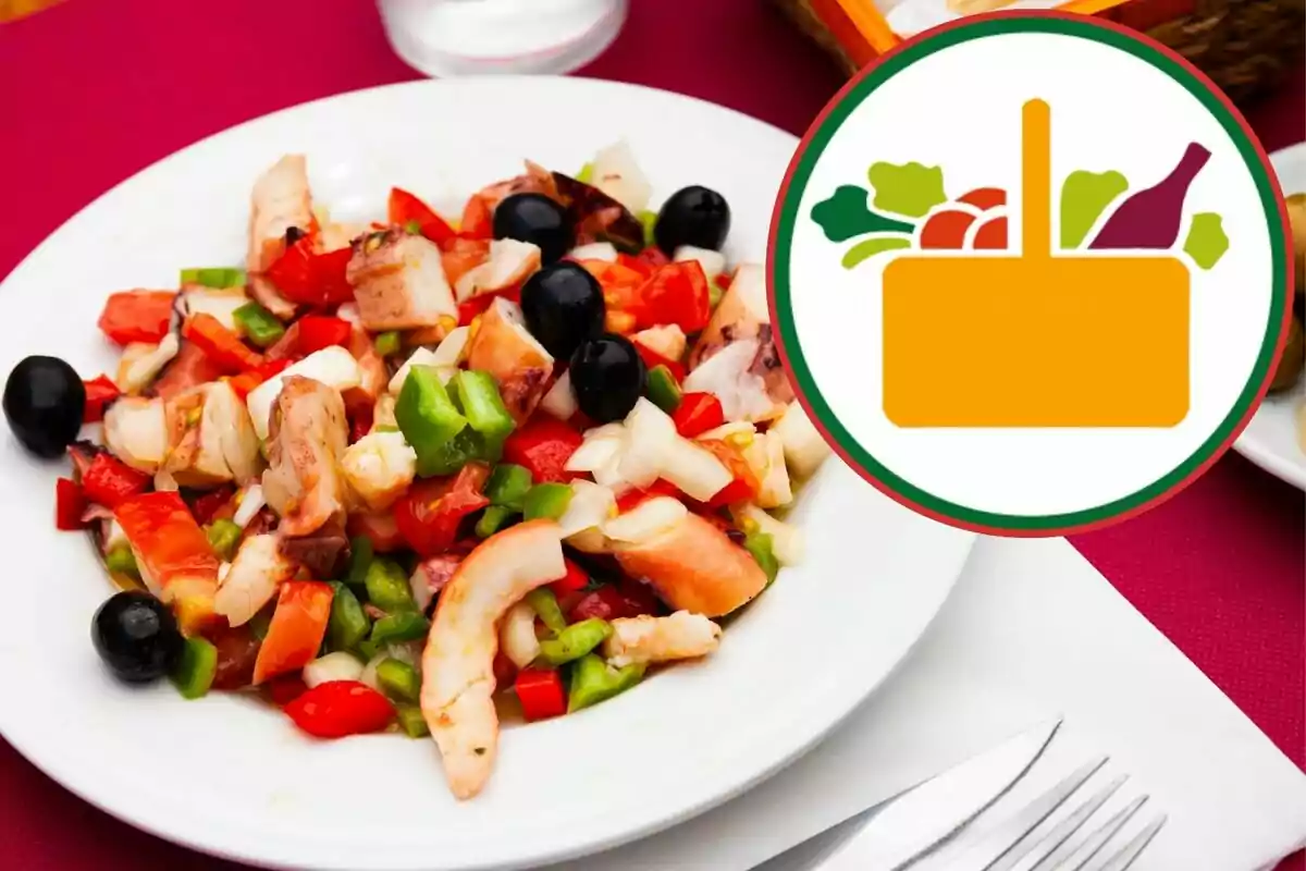 Un plato de ensalada de mariscos con pimientos, cebolla y aceitunas negras sobre una mesa con un icono de cesta de alimentos al lado. Un plato de ensalada de mariscos con pimientos, cebolla y aceitunas negras sobre una mesa con un icono de cesta de alimentos al lado.