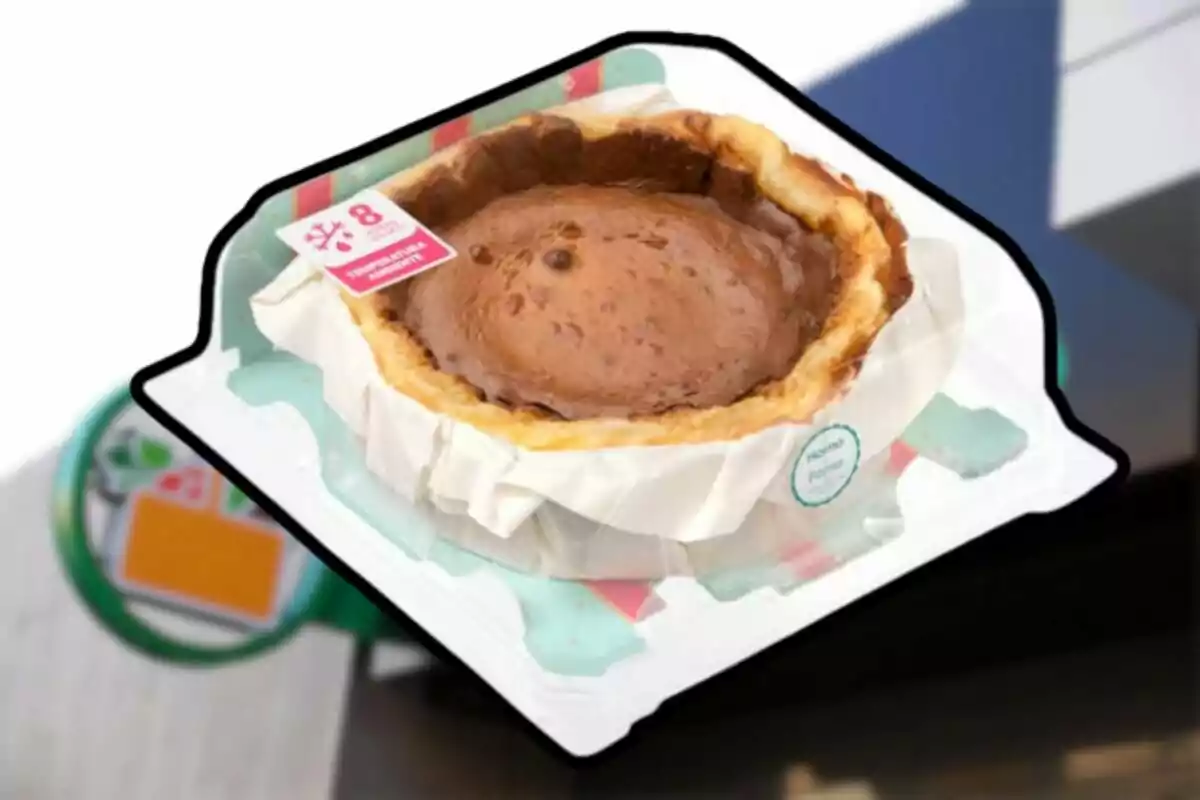 Un pastel de chocolate envuelto en un empaque transparente con una etiqueta roja y blanca. Un pastel de chocolate envuelto en un empaque transparente con una etiqueta roja y blanca.