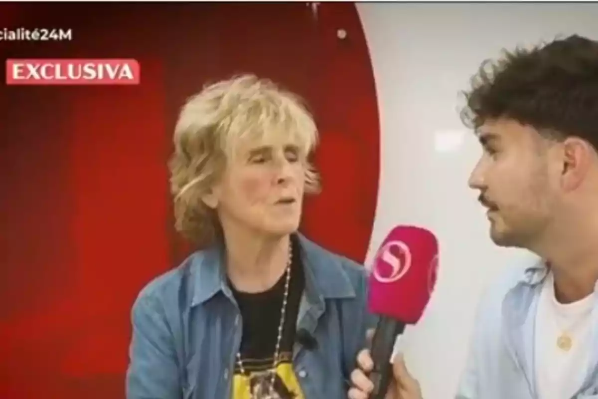 Mercedes Milá siendo entrevistada por un joven que sostiene un micrófono rosa en 'Socialité' Mercedes Milá siendo entrevistada por un joven que sostiene un micrófono rosa en 'Socialité'