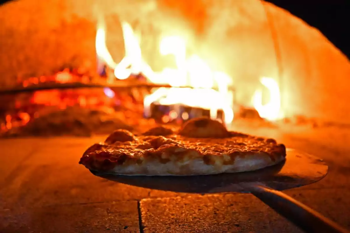 Pizza recién horneada en un horno de leña.