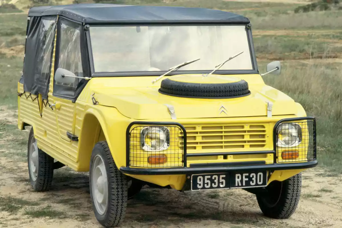 Un Citroën Méhari amarillo con techo de lona negra y matrícula 9535 RF30 estacionado en un entorno natural.