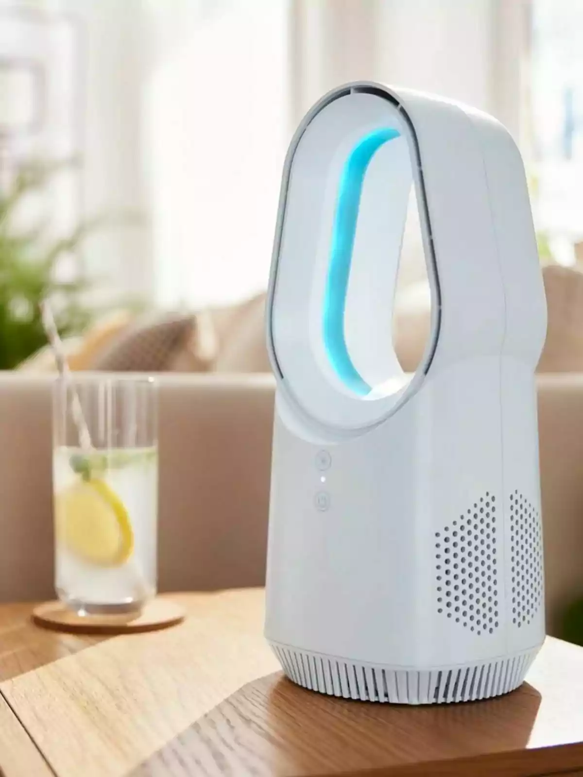 Ventilador sin aspas de color blanco de Lidl sobre una mesa de madera junto a un vaso con agua, rodajas de limón y una pajilla, en un ambiente iluminado y moderno. Ventilador sin aspas de color blanco de Lidl sobre una mesa de madera junto a un vaso con agua, rodajas de limón y una pajilla, en un ambiente iluminado y moderno.
