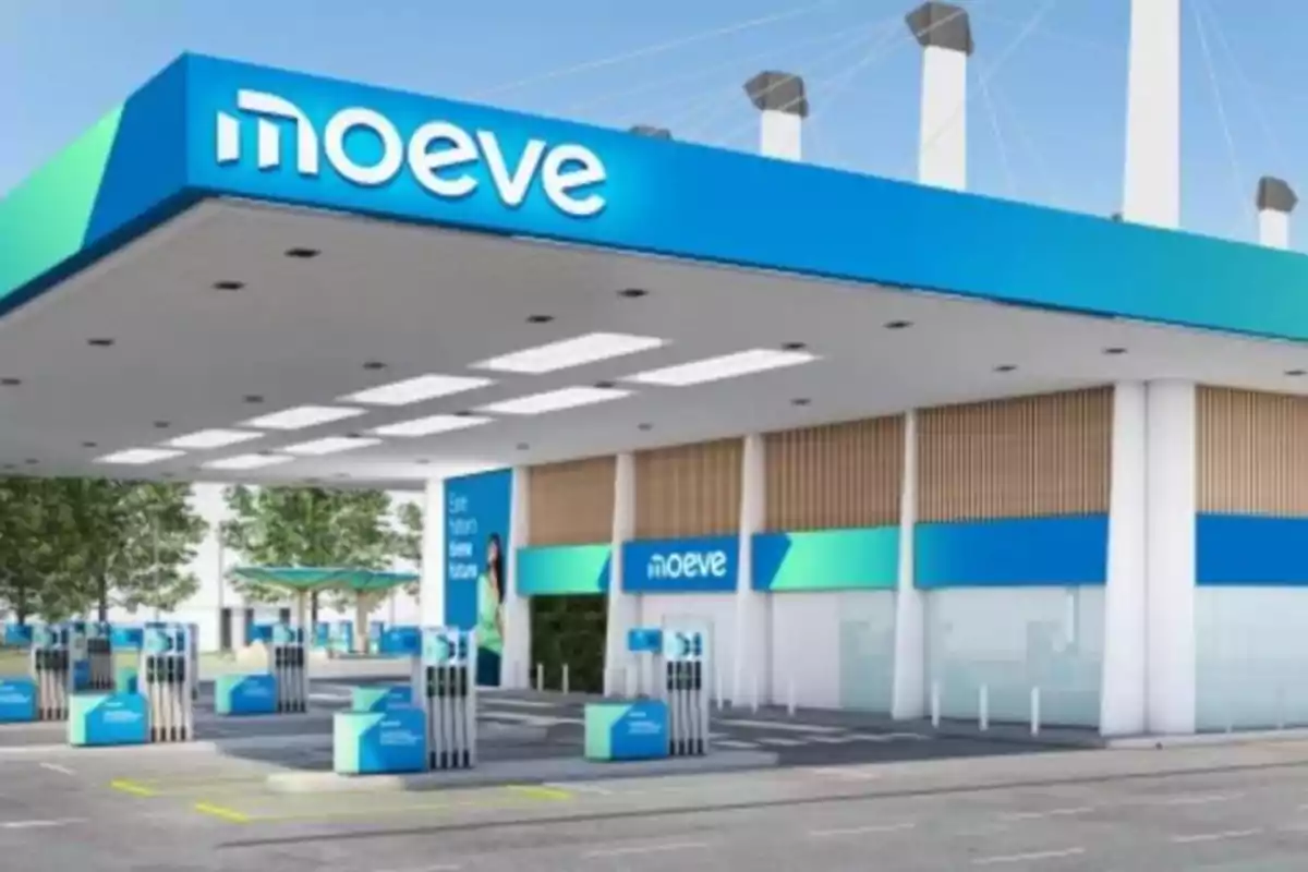 Estación de servicio moderna con diseño en tonos azules y verdes, con varias bombas de combustible y un letrero que dice 