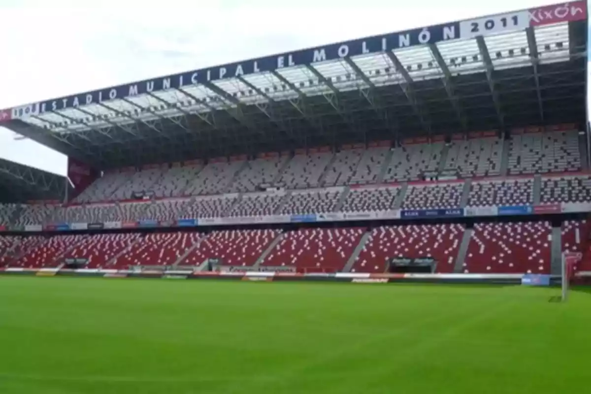 Vista del Estadio Municipal El Molinón con gradas vacías y césped verde.