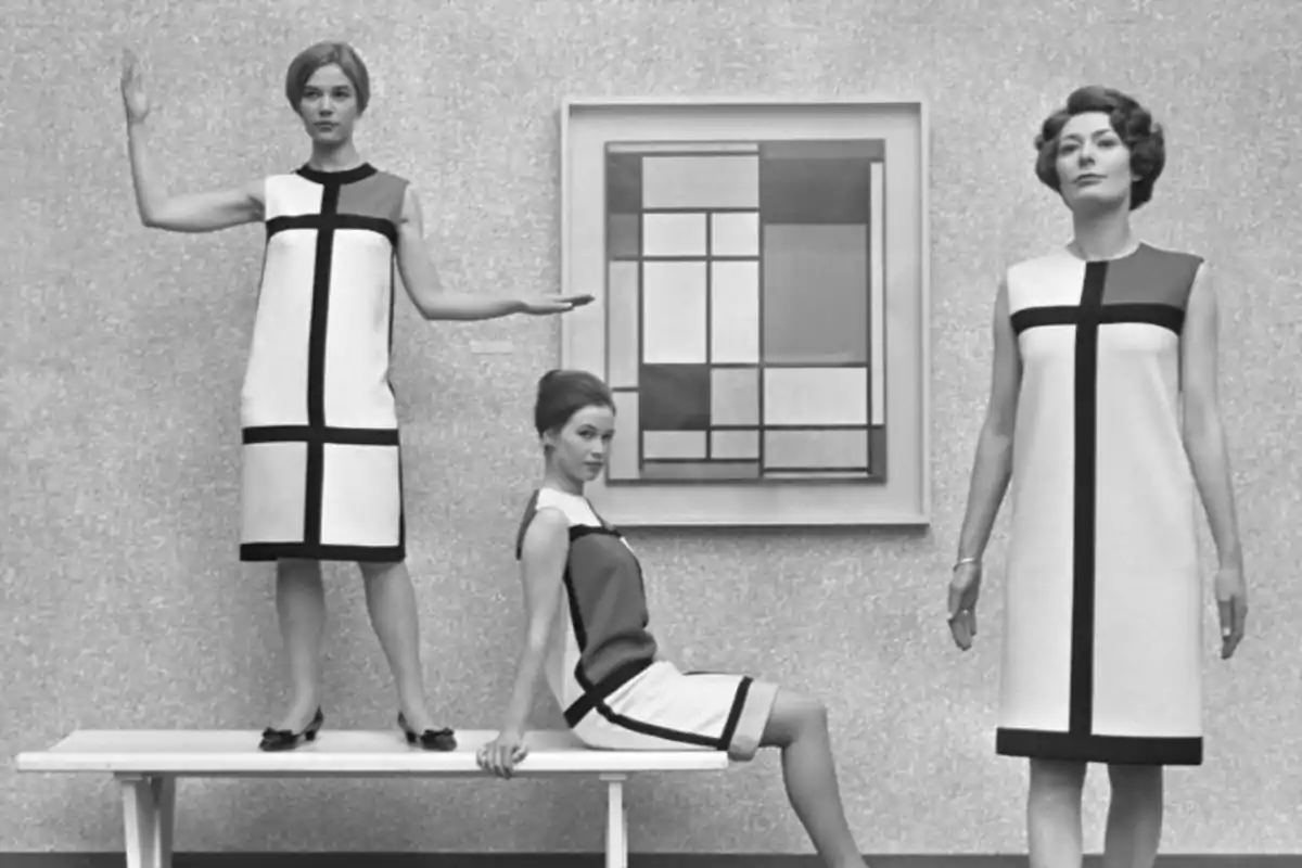 Tres mujeres posan con vestidos geométricos inspirados en el arte moderno frente a una pintura abstracta en blanco y negro Tres mujeres posan con vestidos geométricos inspirados en el arte moderno frente a una pintura abstracta en blanco y negro