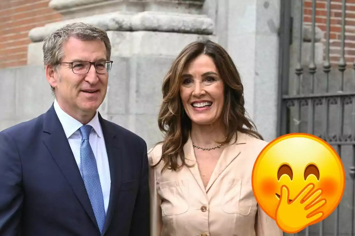 Alberto Núñez Feijoó y Eva Cárdenas sonrientes posando frente a un edificio de piedra, con un emoji de risa cubriéndose la boca superpuesto en la esquina inferior derecha.