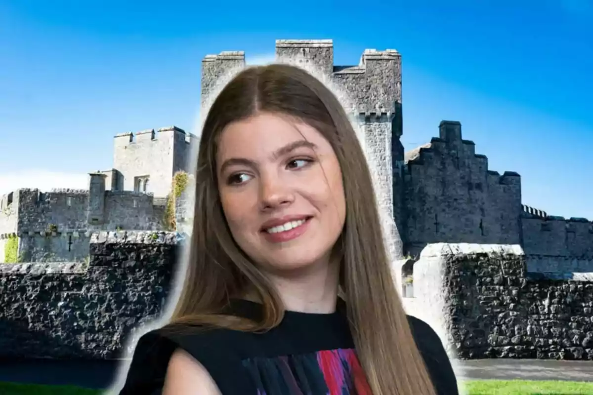 La infanta Sofía sonriendo con un castillo de piedra de fondo bajo un cielo azul.