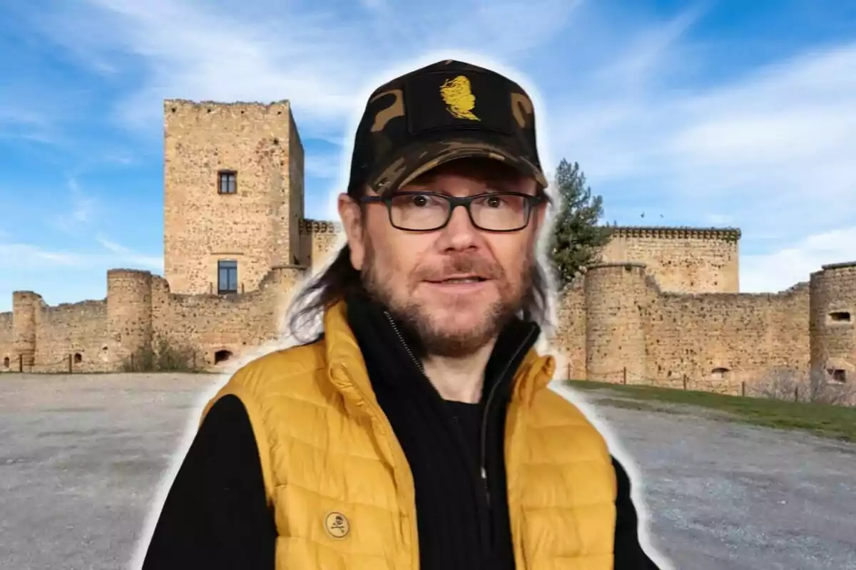 Santiago Segura con gorra frente a un castillo de piedra.