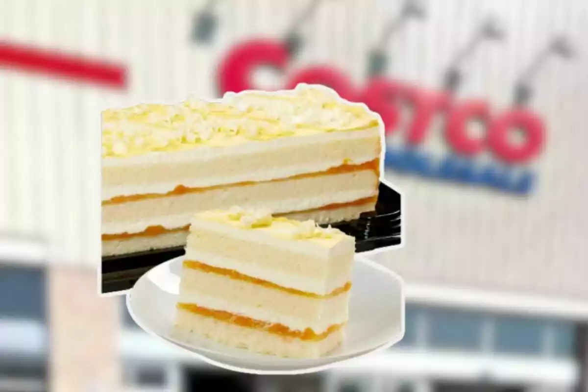 Pastel de capas con relleno de crema y mermelada de durazno sobre un plato blanco frente a una tienda Pastel de capas con relleno de crema y mermelada de durazno sobre un plato blanco frente a una tienda