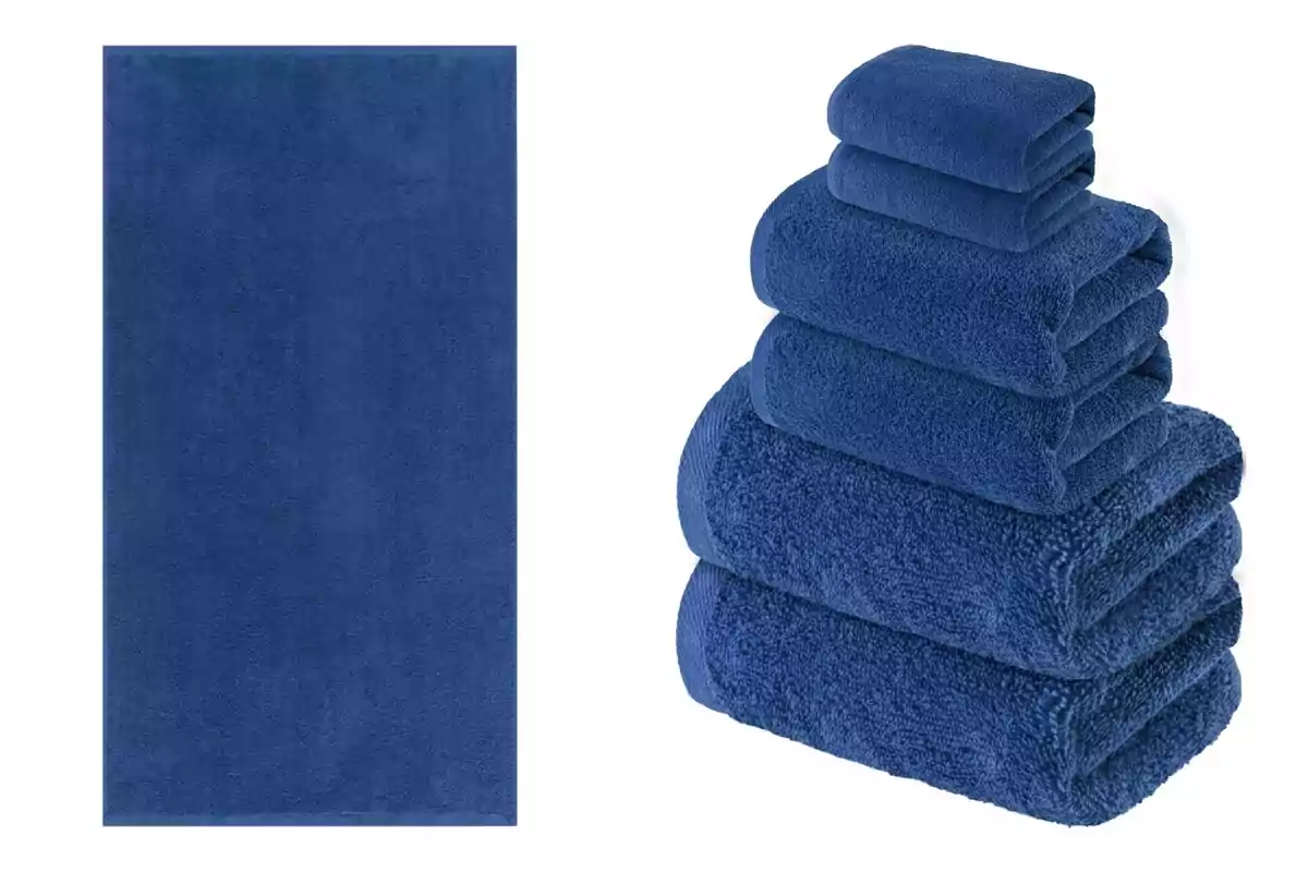 Un conjunto de toallas azules, con una toalla extendida a la izquierda y una pila de toallas dobladas de diferentes tamaños a la derecha que son de Lidl. Un conjunto de toallas azules, con una toalla extendida a la izquierda y una pila de toallas dobladas de diferentes tamaños a la derecha que son de Lidl.