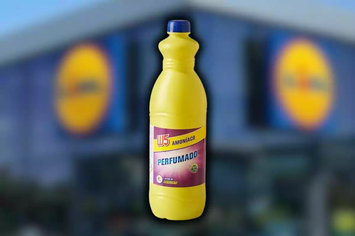 Botella amarilla de amoníaco perfumado de Lidl con tapa azul y etiqueta morada, con un fondo desenfocado de un edificio. Botella amarilla de amoníaco perfumado de Lidl con tapa azul y etiqueta morada, con un fondo desenfocado de un edificio.