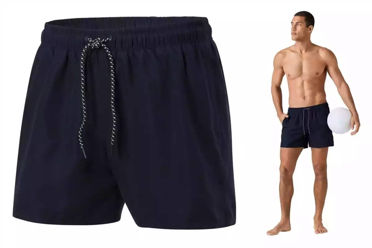 Un hombre en traje de baño negro de Lidl sostiene una pelota blanca, con un enfoque en el diseño del short que tiene un cordón ajustable. Un hombre en traje de baño negro de Lidl sostiene una pelota blanca, con un enfoque en el diseño del short que tiene un cordón ajustable.